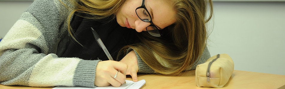 student writing diligently